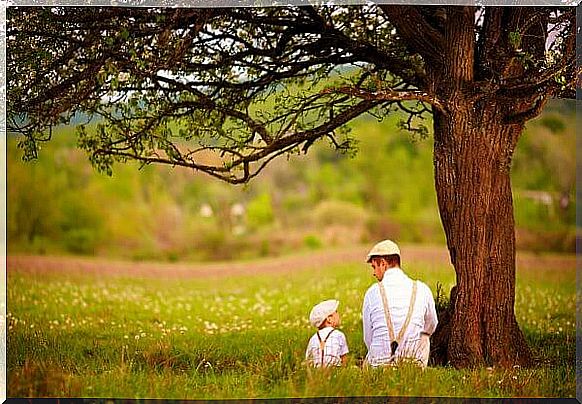 Father and children under a tree