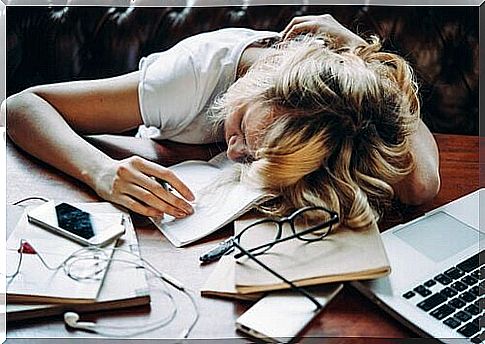 Tired woman with her head on the desk.