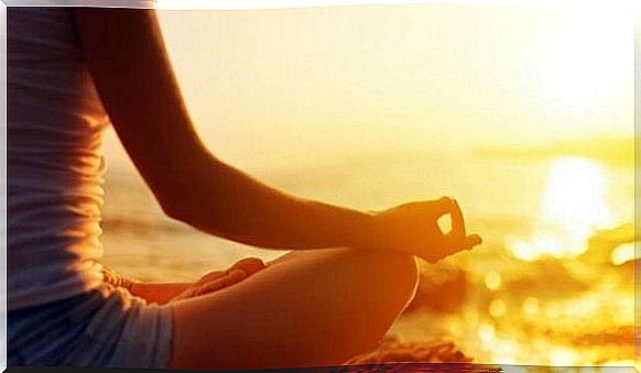 Woman meditating on the beach