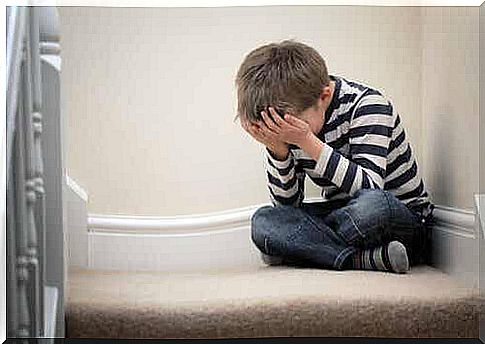 A little boy with anxiety is sitting on the stairs