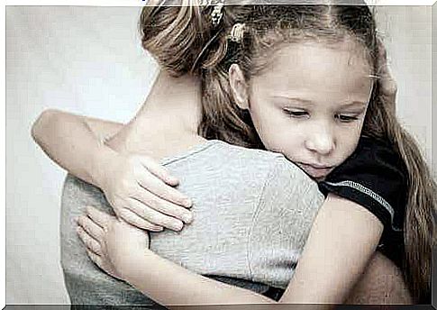 A woman hugs a little girl