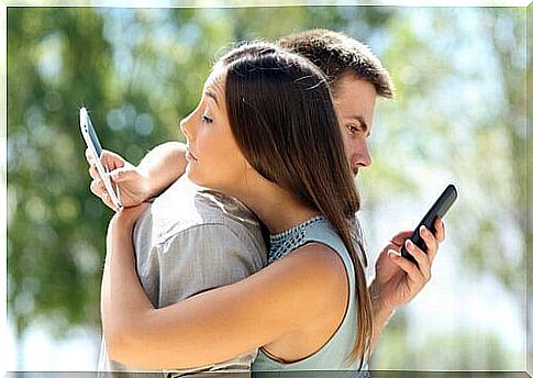 Couples hug each other while using their phones