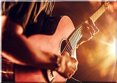 Playing guitar in front of an audience.