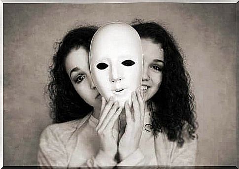 A black and white image of the face of two seemingly identical women hiding behind a mask.