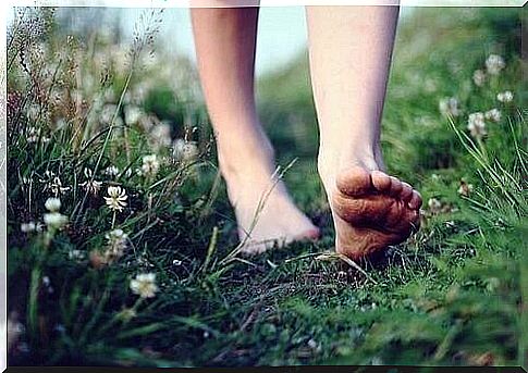 a person walking barefoot in the grass