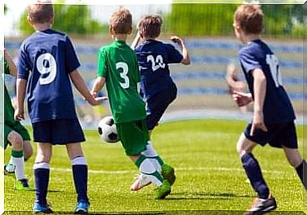 More young boys playing football.