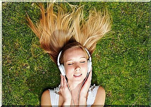 Girl lying on the grass listening to music