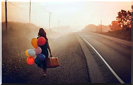 Woman with balloons and a suitcase