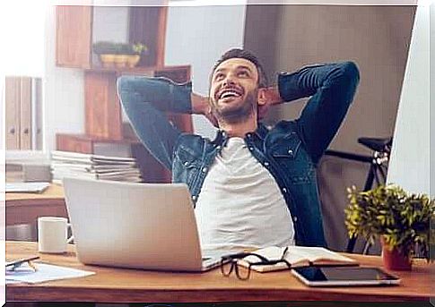 A man sitting at a desk looking happy.